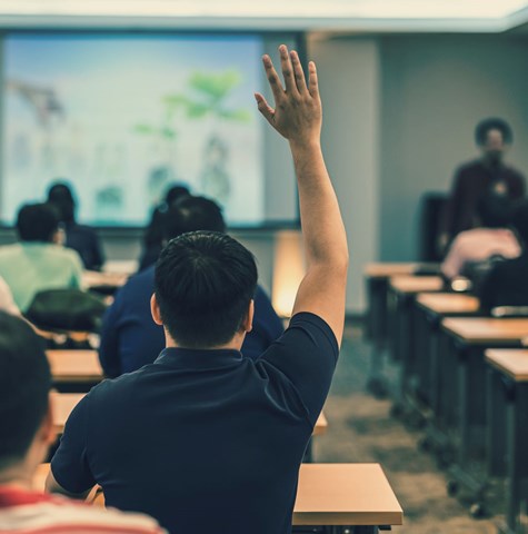 A man raising his hand during a lecture at a workshop